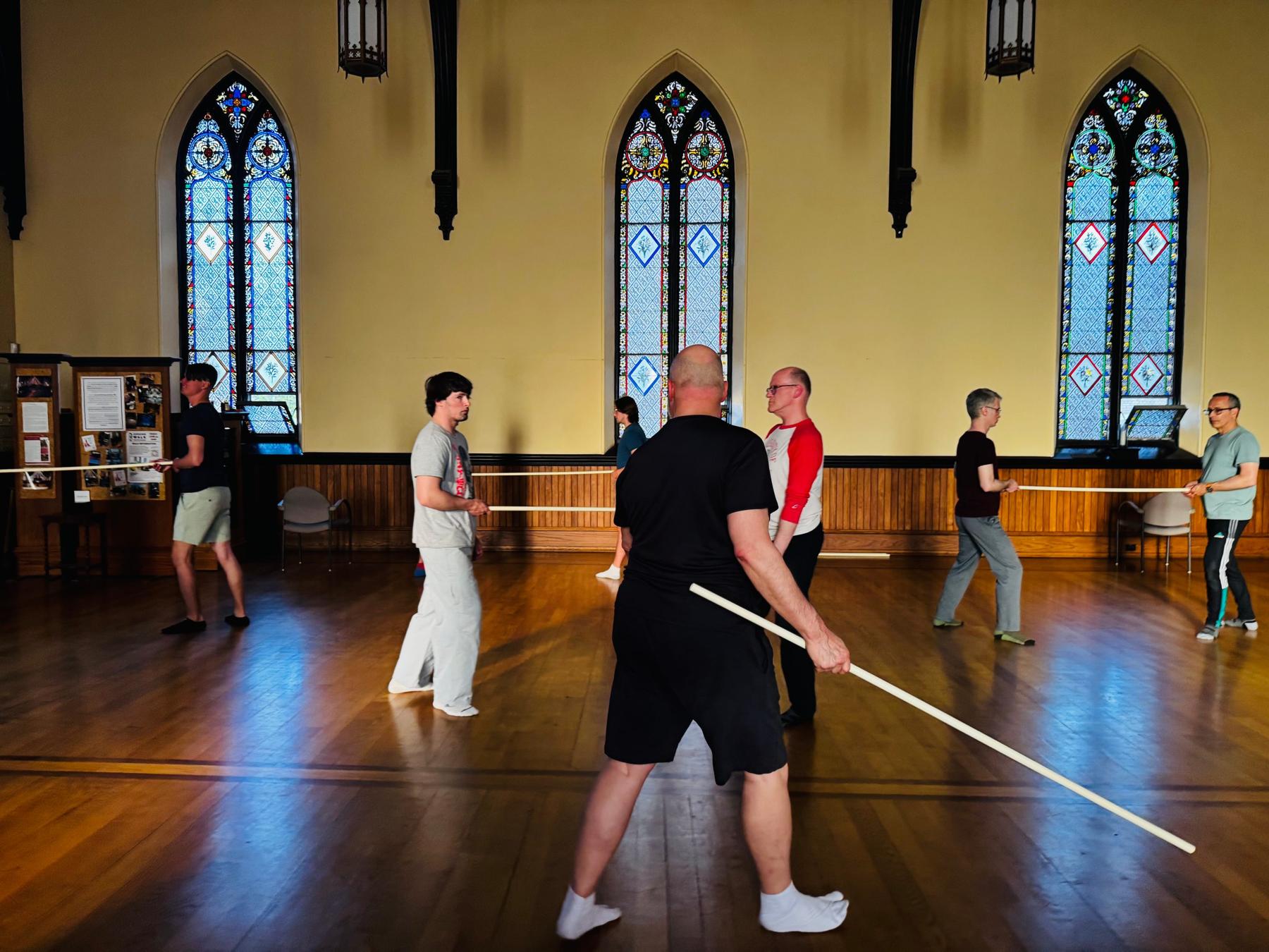 WCS Actors Studio class in session — actors moving through a staff exercise in a stained-glass hall