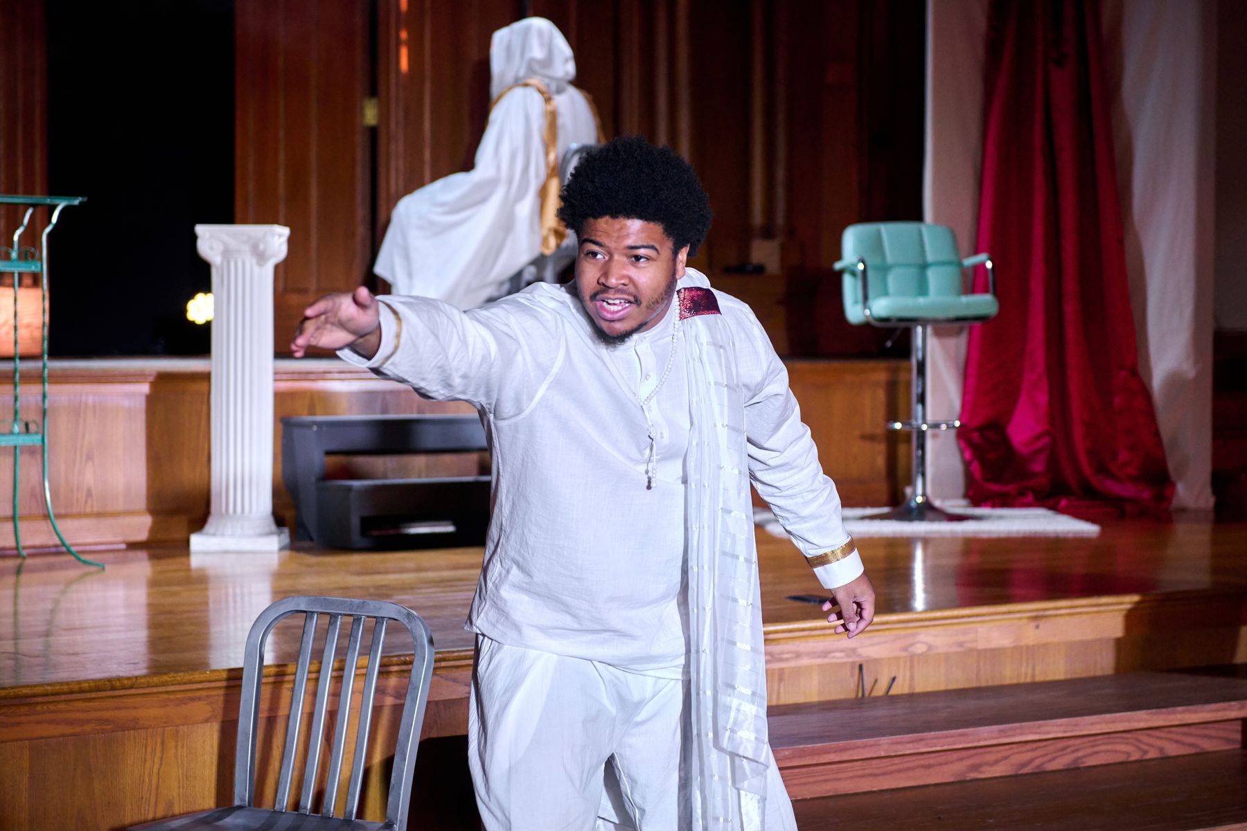 A performer mid-scene, arm outstretched, in Wisconsin Classic Stage's production of The Persians